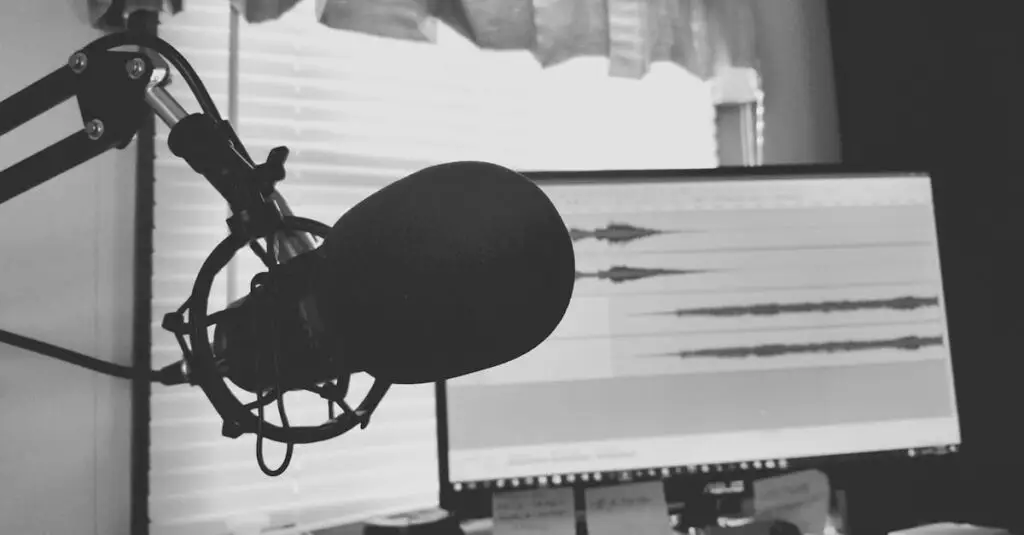 Black and white image of a podcast setup with microphone and waveform screen.