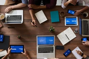 pexels-photo-3183150-3183150 Overhead view of a diverse team in a business meeting using laptops and tablets.